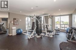 Fitness area featuring resilient flooring, recessed lighting, and large windows with arched accents - 