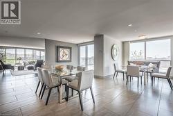 Expansive living area with large format tile flooring, recessed lighting, and a wall of windows - 