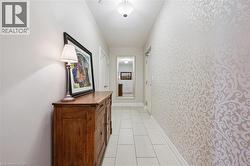 Hallway featuring tile flooring, neutral wall tones, patterned accent wall, and a flush mount ceiling light - 