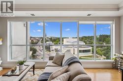 Expansive window wall with roller shades, wood-finish flooring, and crown molding - 