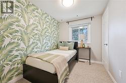 Wall-to-wall carpeting, single window with white trim, white paneled door, flush-mount ceiling light fixture, and a decorative accent wall - 