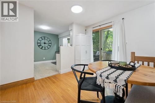 Hardwood flooring extends through the dining area, complemented by a built-in storage cabinet and a sliding glass door leading to an exterior deck - 135 Bridge Street W, Waterloo, ON 