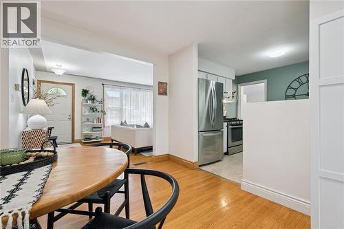 Open-concept living area with wood-finish flooring extending into the dining space - 135 Bridge Street W, Waterloo, ON 