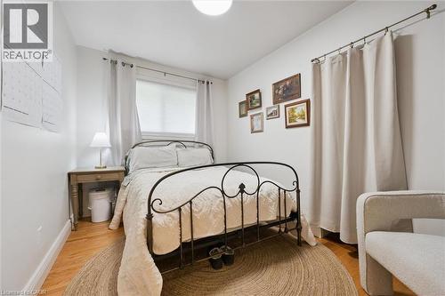 Wood-finish flooring, white walls, and a window with blinds and curtains - 135 Bridge Street W, Waterloo, ON 