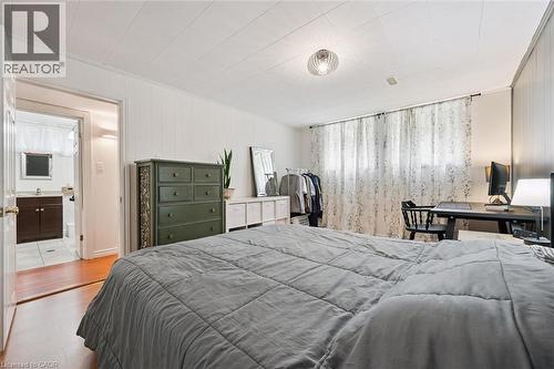 Spacious room featuring paneled walls, wood-finish flooring, and a ceiling light fixture - 135 Bridge Street W, Waterloo, ON 