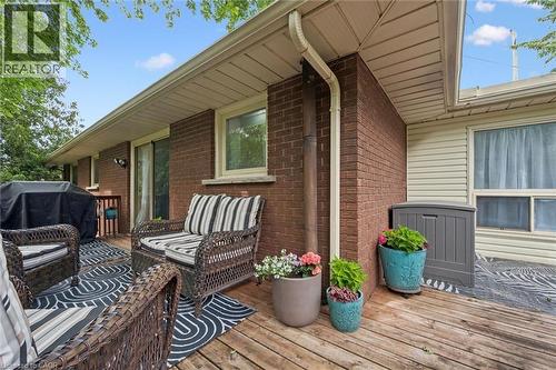 Expansive wood deck with brick exterior, sliding glass door, and exterior lighting fixtures - 135 Bridge Street W, Waterloo, ON 