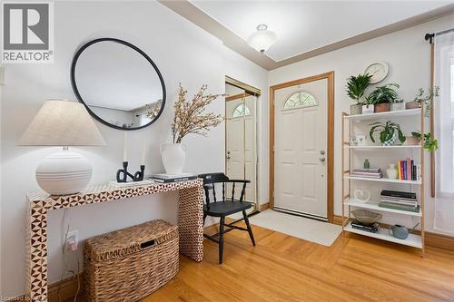 Entryway featuring wood-finish flooring, a paneled entry door with an arched glass insert, and a built-in mirrored closet - 135 Bridge Street W, Waterloo, ON 