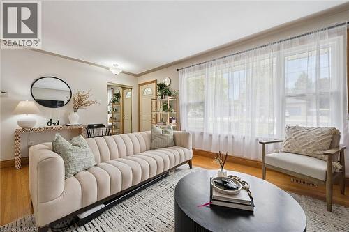 Living area featuring wood-finish flooring, a large window array, and a flush mount ceiling light fixture - 135 Bridge Street W, Waterloo, ON 