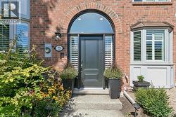 Brick facade with a prominent arched entryway and a dark panel door - 