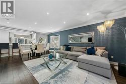 Open-concept living area featuring dark wood-finish flooring, recessed lighting, and a kitchen pass-through - 