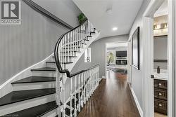 Curved staircase with dark treads and white balusters - 
