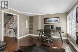 Rich wood-finish flooring, built-in shelving, recessed ceiling lights, crown molding, and plantation shutters - 