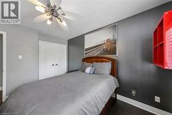Wood-finish flooring, ceiling fan with light fixture, and white bi-fold closet doors - 