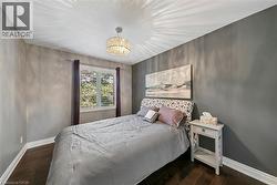 Wood-finish flooring, window with interior shutters, drum chandelier, and a built-in nightstand - 