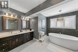 Freestanding soaking tub with a distinct stone-look accent wall - 