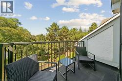 Balcony with metal railings, a textured stucco exterior wall, and a sloped roofline - 