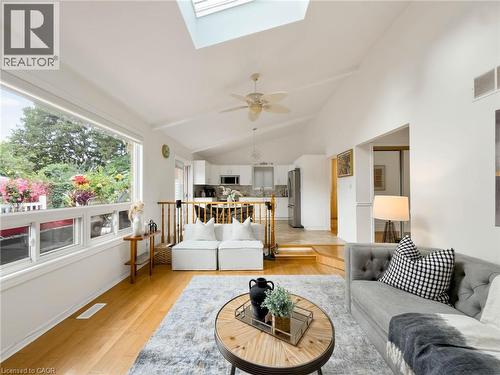 Vaulted ceiling with skylight, wood-finish flooring, large picture window, ceiling fan, and recessed kitchen - 1236 Thorpe Road, Burlington, ON 