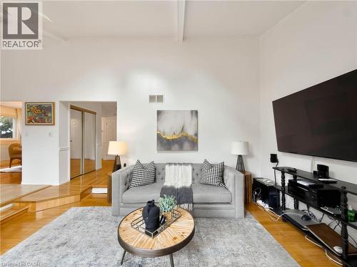 Vaulted ceiling with exposed beam, wood-finish flooring, recessed lighting, and mirrored closet doors - 1236 Thorpe Road, Burlington, ON 