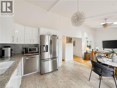 Kitchen featuring white cabinetry, stainless steel appliances, granite countertops, and a tiled backsplash - 1236 Thorpe Road, Burlington, ON 