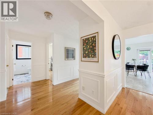 Wood-finish flooring throughout, white wainscoting details, recessed ceiling light, and white walls - 1236 Thorpe Road, Burlington, ON 