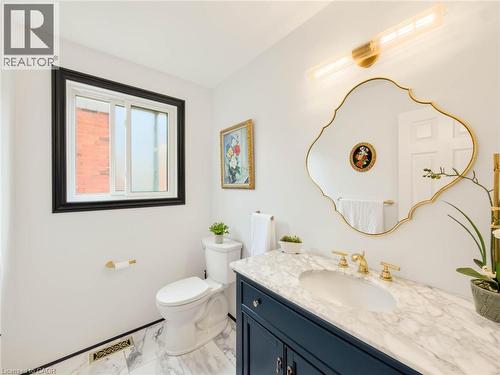 Vanity with stone-finish countertop, undermount sink, and brass-finish fixtures - 1236 Thorpe Road, Burlington, ON 