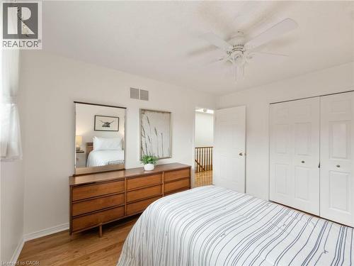 Light wood-finish flooring, white walls, ceiling fan, bi-fold closet doors, and wood newel post - 1236 Thorpe Road, Burlington, ON 
