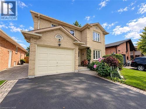Brick exterior with a peaked roofline, attached garage, and mature landscaping - 1236 Thorpe Road, Burlington, ON 