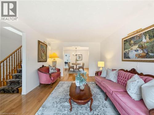 Hardwood flooring, painted white walls, and a staircase with wood banister and carpeted treads - 1236 Thorpe Road, Burlington, ON 
