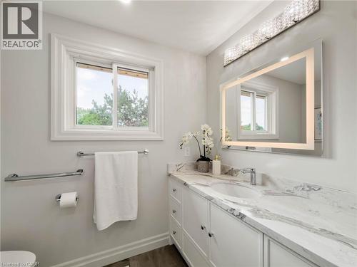Vanity with integrated sink, stone-finish countertop, and white cabinetry - 1236 Thorpe Road, Burlington, ON 