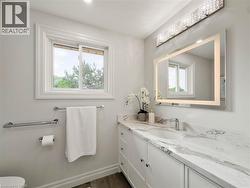 Vanity with integrated sink, stone-finish countertop, and white cabinetry - 