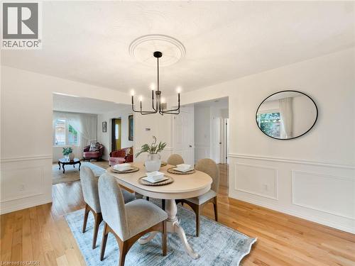 Hardwood flooring, decorative wainscoting, and a modern chandelier with a ceiling medallion - 1236 Thorpe Road, Burlington, ON 