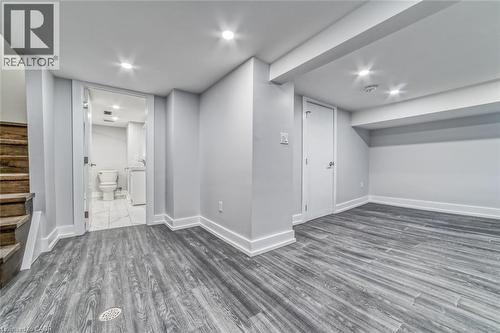 Recessed lighting illuminates the wood-finish flooring and light gray walls - 23 Gibson Avenue, Hamilton, ON 