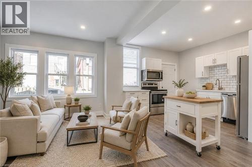 Open-concept living space featuring wood-finish flooring, recessed lighting, and white trim - 23 Gibson Avenue, Hamilton, ON 