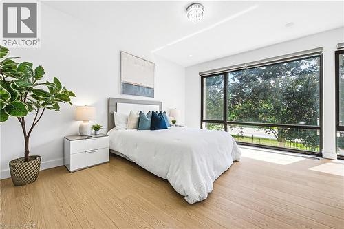 Expansive floor-to-ceiling windows, wood-finish flooring, recessed lighting, and a modern ceiling fixture - 4511 Guelph Line, Burlington, ON 