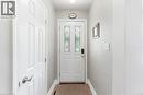Entryway featuring a white door with decorative glass inserts, a smart lock, and light gray wall paint - 1063 Joan Drive, Burlington, ON 