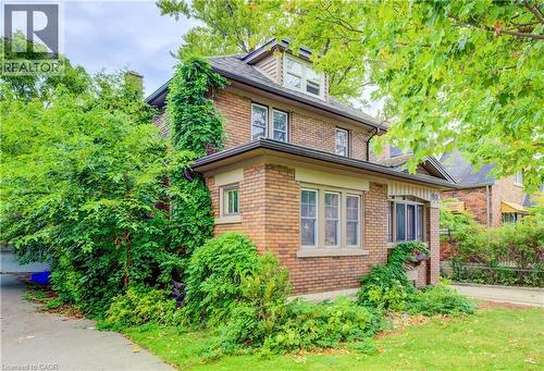 Brick exterior with dormer window, multiple pane windows, and established landscaping - 90 Brock Street, Kitchener, ON 