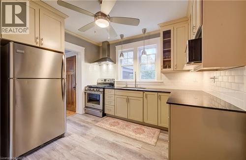 Kitchen featuring stainless steel appliances, wood-finish flooring, recessed lighting, and a subway tile backsplash - 90 Brock Street, Kitchener, ON 
