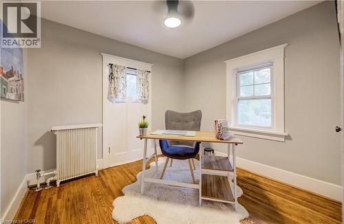 Hardwood flooring, painted walls, window with trim, radiator, and ceiling light fixture - 90 Brock Street, Kitchener, ON 