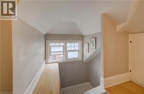 Attic space featuring sloped ceilings, a double window, wood-finish flooring, and painted walls - 90 Brock Street, Kitchener, ON 