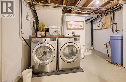 Laundry area with side-by-side appliances, a wood-finish countertop, and exposed ceiling joists - 90 Brock Street, Kitchener, ON 
