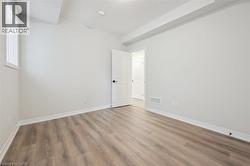Neutral wall color, wood-finish flooring, white trim, recessed lighting, and white interior doors - 