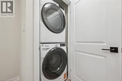 Dedicated laundry area featuring a stacked washer and dryer - 