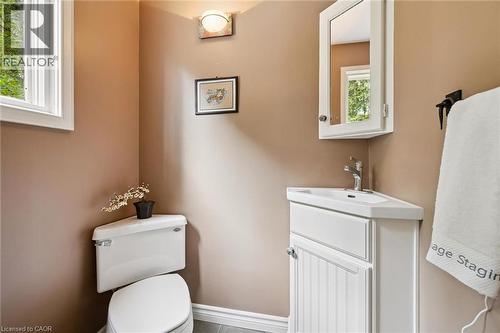 Corner vanity with integrated sink, white wood-finish cabinetry, and wall-mounted mirrored medicine cabinet - 334 Coleridge Drive, Waterloo, ON 