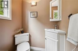 Corner vanity with integrated sink, white wood-finish cabinetry, and wall-mounted mirrored medicine cabinet - 