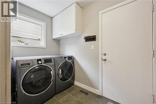 Laundry area featuring a window, overhead cabinetry, and tile flooring - 334 Coleridge Drive, Waterloo, ON 