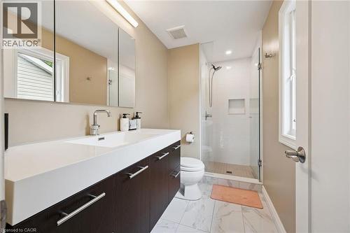 Contemporary vanity with integrated sink, chrome faucet, and dark wood-finish cabinetry - 334 Coleridge Drive, Waterloo, ON 