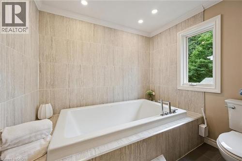 Recessed lighting illuminates the tiled bath surround and walls - 334 Coleridge Drive, Waterloo, ON 