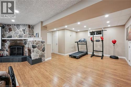 Wood-finish flooring, recessed lighting, and a stone-clad fireplace with a hearth - 334 Coleridge Drive, Waterloo, ON 