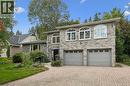 Stone facade with arched windows, an intricate paver driveway, and an attached two-car garage - 334 Coleridge Drive, Waterloo, ON 