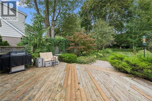 Spacious wood deck with multiple levels, surrounded by mature trees and established landscaping, featuring a private backyard setting - 334 Coleridge Drive, Waterloo, ON 